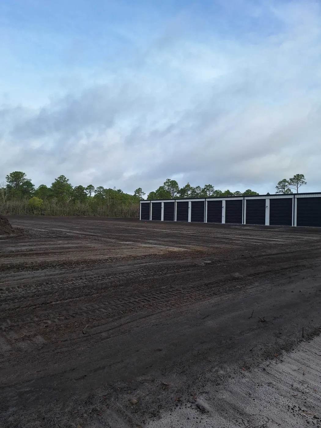 Dark fill dirt hauled in and graded flat for a storage building pad in Pender County, NC
