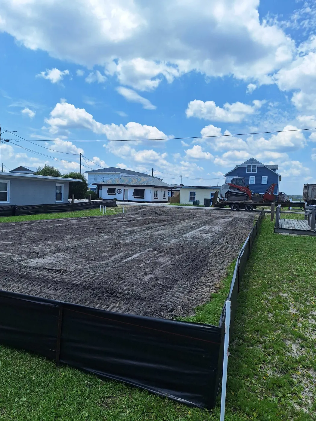 Graded homesite with black silt fence along its edge after residential site prep in southeastern NC