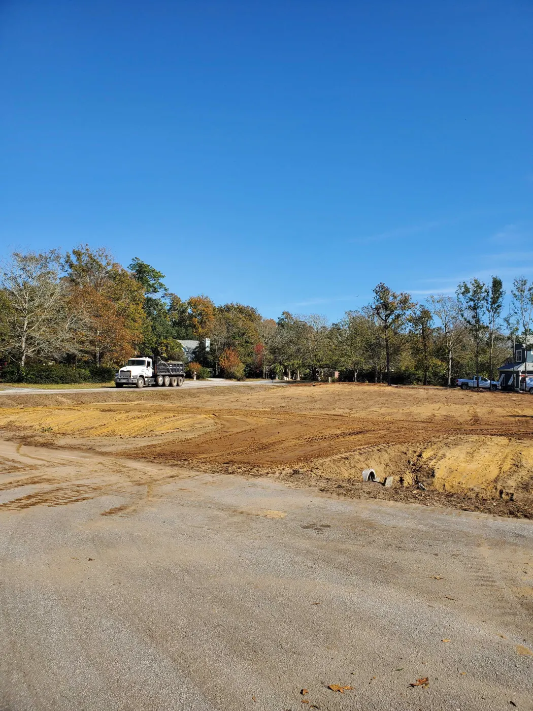 Dump truck beside a freshly graded lot of hauled-in fill dirt in southeastern North Carolina